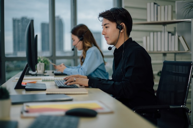 Équipe de support client asiatique avec casque travaillant au bureau.