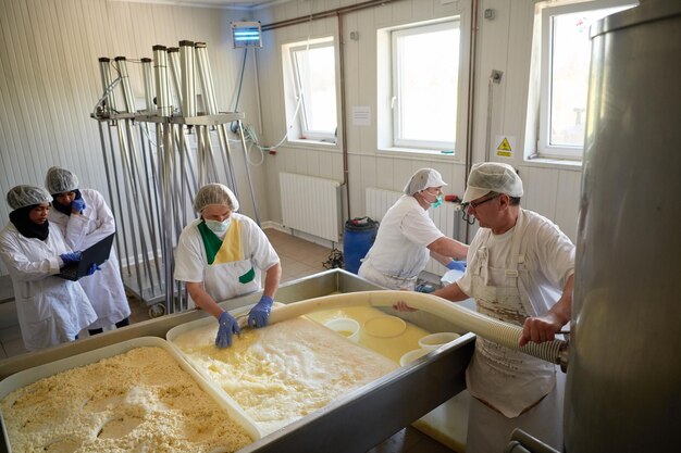 Équipe de travailleurs préparant du lait cru pour la production de fromage dans une usine locale