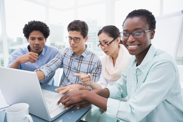 Équipe de vêtements de travail ayant une réunion en utilisant un ordinateur portable