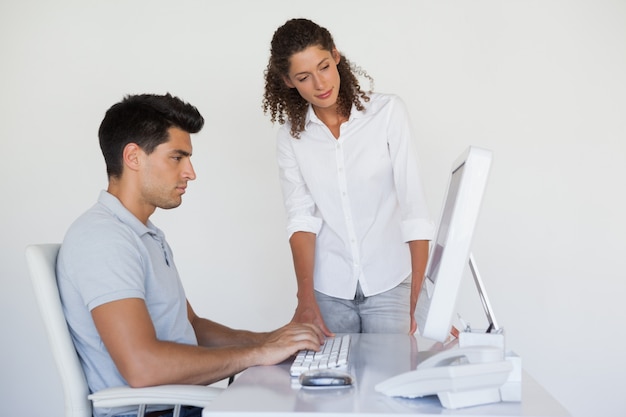 Équipe de vêtements de travail regardant l&#39;ordinateur ensemble au bureau