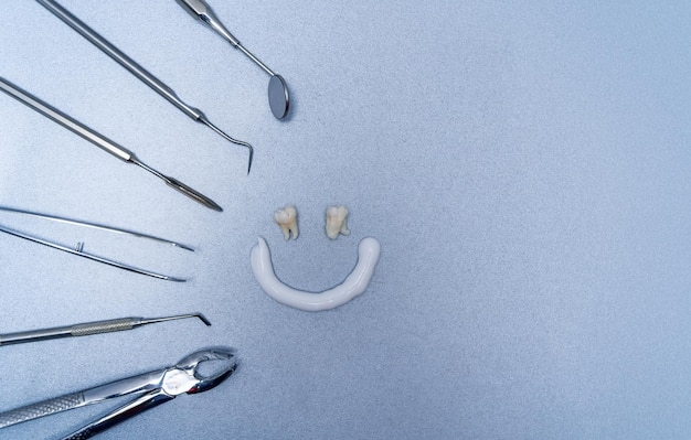 Équipement de dentiste pour le travail Composition du visage souriant et différents outils