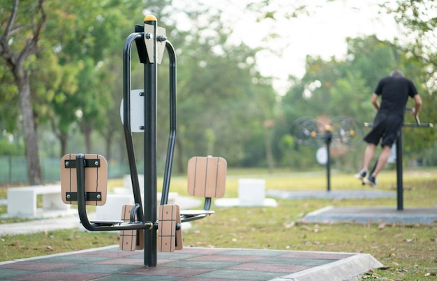 Équipement de fitness en plein air avec un homme flou faisant de l'exercice à l'arrière-plan