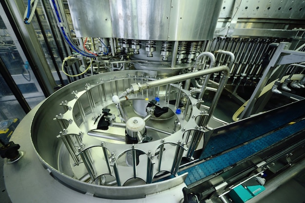 Équipement moderne pour le remplissage de bière, boissons gazeuses, eau en bouteilles. Production industrielle de boissons.