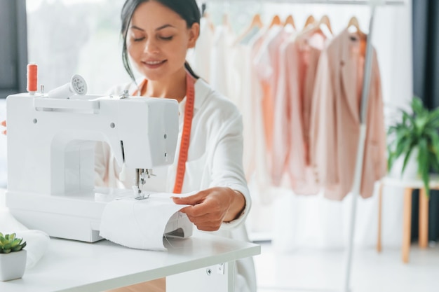 Équipement professionnel La couturière est dans son bureau avec des vêtements différents