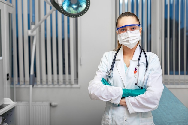 Équipement de protection individuelle, femme médecin posant avec masque chirurgical blanc