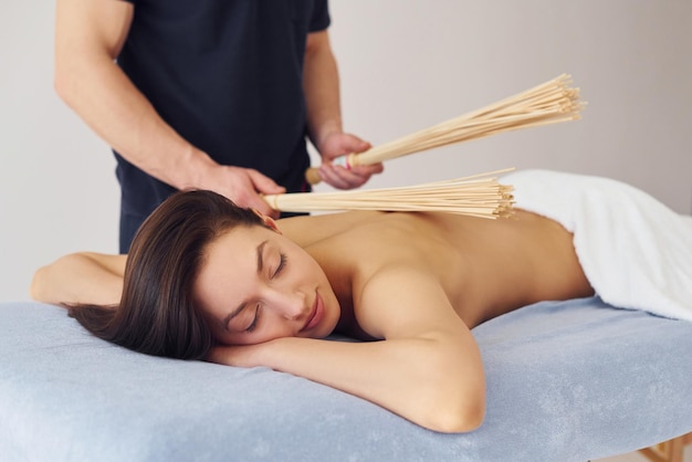 Équipement spécial Une jeune femme est allongée quand un homme fait un massage de son corps au spa