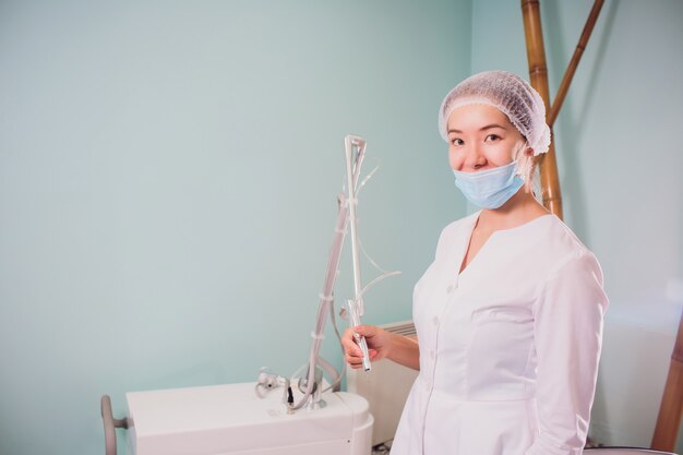 Équipement de traitement de la peau .. Gros plan esthéticienne à l'aide de la machine de beauté au centre de cosmétologie, salon de beauté.