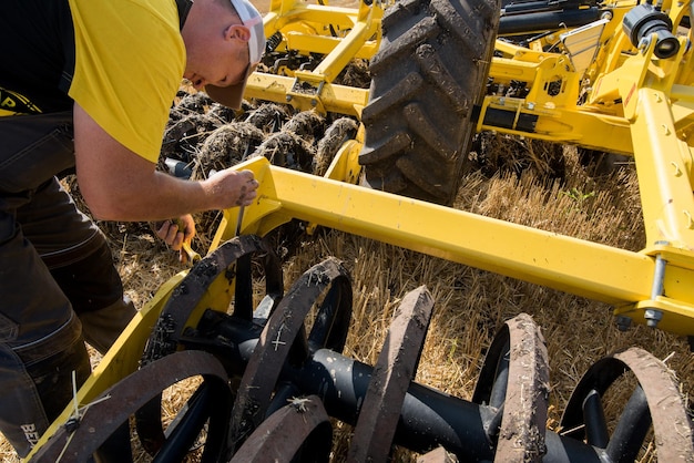 RÉGION DE TERNOPIL, UKRAINE - 10 août 2021 : un homme inspecte un cultivateur de tracteur lors d'une démonstration de machines agricoles, exposition de la société "Lan"