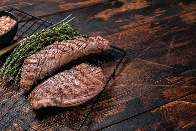 Rabat de surlonge grillé ou steak de viande de bœuf Bavette sur un gril aux herbes Fond en bois Vue de dessus Espace de copie