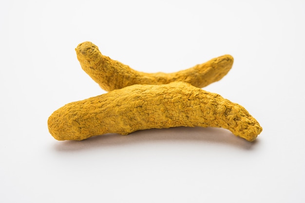 Racines de curcuma séchées ou sookhi Haldi dans son ensemble sur une surface blanche, mise au point sélective