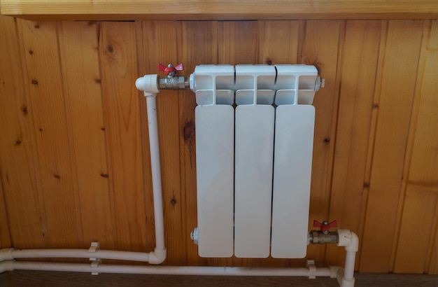 Le radiateur d'un appareil de chauffage domestique sur le fond d'un mur en bois dans un appartement russe typique ou une maison privée