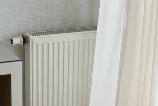 Radiateur de chauffage sous fenêtre dans la chambre