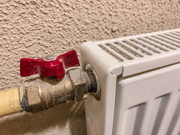 Photo radiateur pour fournir du chauffage aux appartements résidentiels batterie blanche avec un robinet rouge