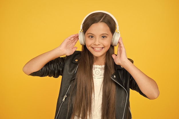 Radio scolaire dj dame DJ cheveux longs sourire heureux hipster style urbain fille style de vie concept motard enfant dans le casque petite fille en veste en cuir automne mode style enfant écouter de la musique rock