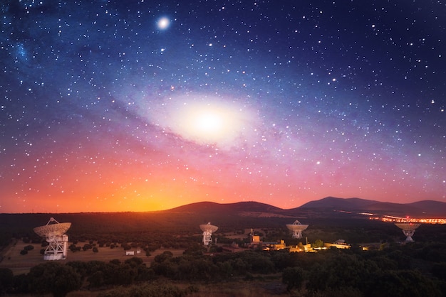 Radio télescopes de nuit avec galaxie dans le ciel