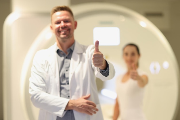 Photo radiologue masculin et patiente montrant les pouces vers le haut près du scanner ct dans le concept d'hôpital de