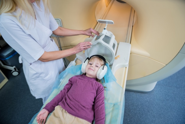 Le radiologue prépare la petite fille pour un examen cérébral IRM