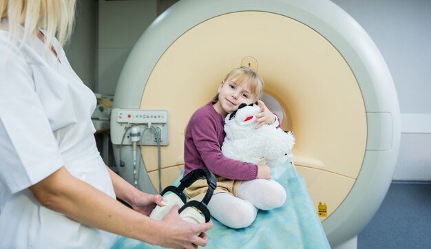 Photo le radiologue prépare la petite fille pour un examen cérébral irm