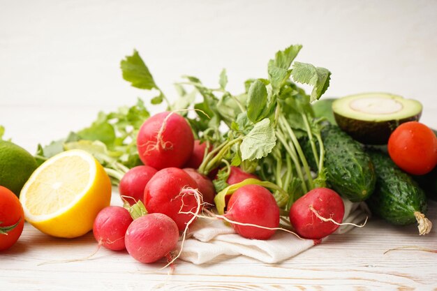 Radis et autres légumes de printemps sur un fond de bois Gros plan