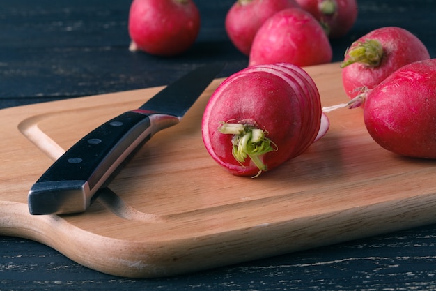 Radis frais en tranches sur une planche à découper