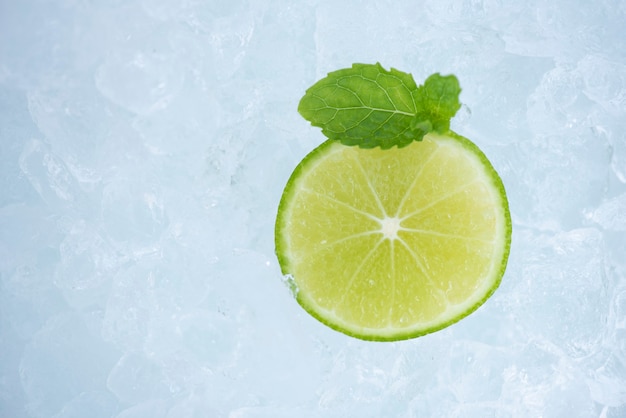 Rafraîchissement d'été de boissons froides fruits frais tranche de citron vert sur glace avec feuille de menthe, vue de dessus