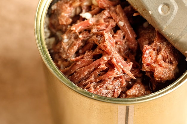 Photo ragoût de boeuf dans un bocal métallique viande en conserve bocal ouvert avec ragoût de boeuf tushenka russe close up