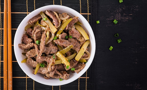 Ragoût de bœuf, morceaux de bœuf cuits à la sauce soja aux épices et concombre mariné à l'asiatique. Vue de dessus, frais généraux, pose à plat