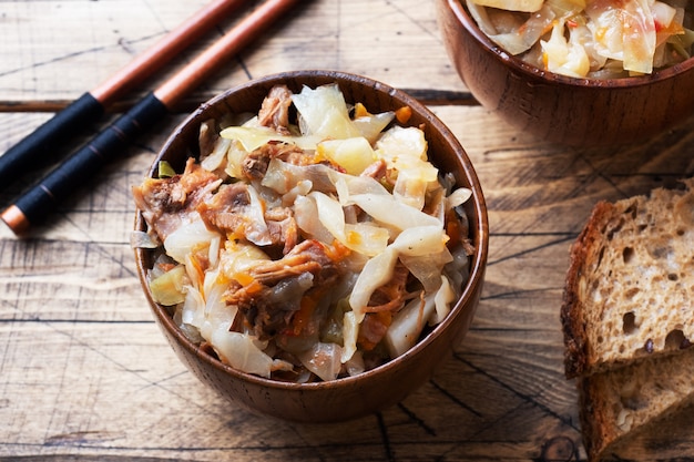 Ragoût de chou avec de la viande dans un bol en bois