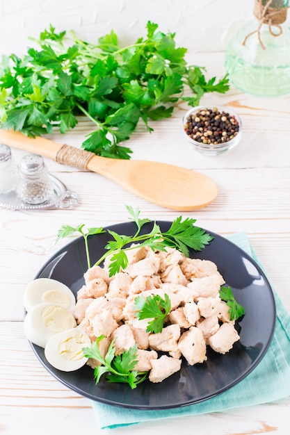 Ragoût de dinde à la crème sure aux épices avec œuf de poule bouilli et herbes fraîches sur une plaque