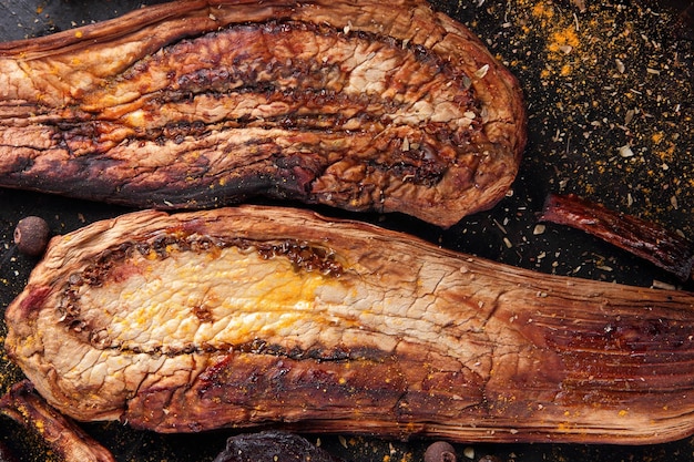 Ragoût de légumes frais cuits au four Tranches cuites au four de betterave aubergine oignon aux épices grains de poivre sur fond sombre Gros plan