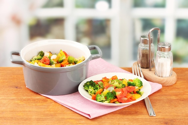 Ragoût de légumes en pot gris sur table en bois sur fond clair