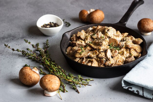 Ragoût de viande avec champignons et thym dans une poêle en fonte