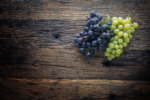 Raisin. Grappe de raisins multicolores sur table en bois rustique.