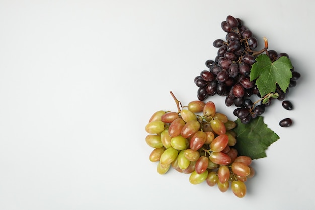 Raisin mûr frais avec des feuilles sur blanc