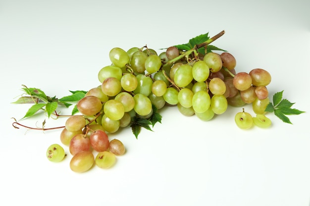 Raisin mûr vert avec des feuilles sur fond blanc