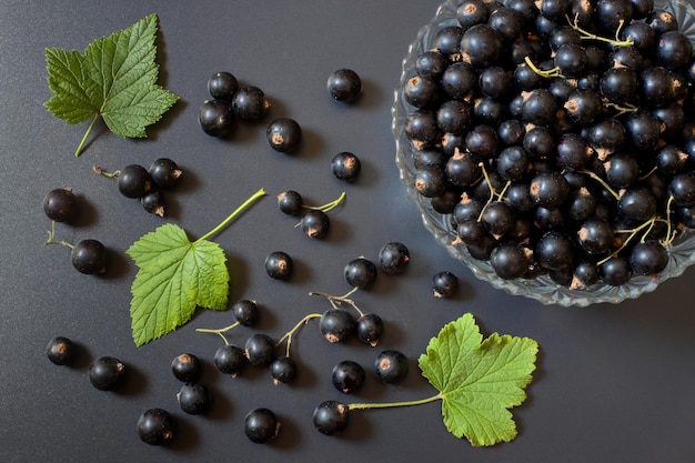 Le raisin noir dans un bol de verre sur une table noire