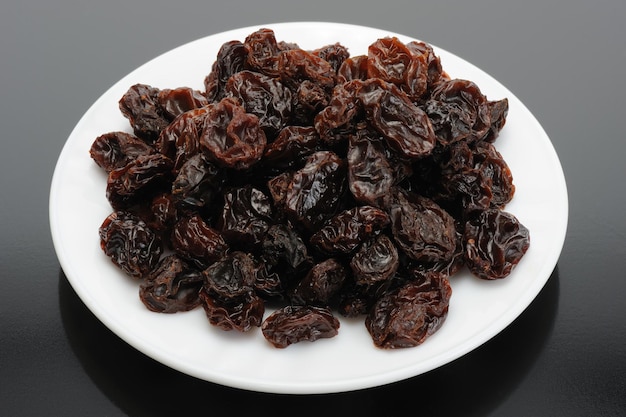 Raisin sur une plaque blanche sur fond noir