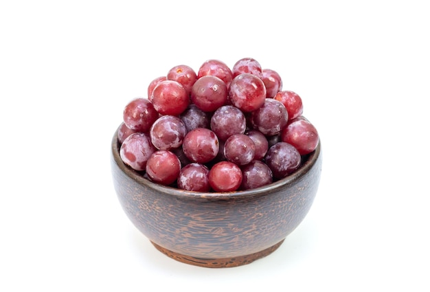 Raisin rouge dans un bol isolé sur fond blanc