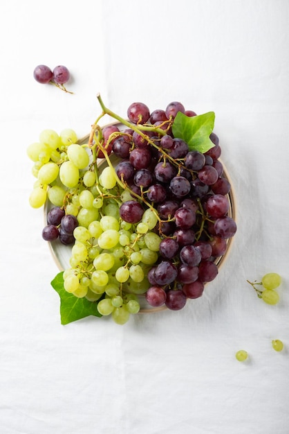 Raisin rouge et jaune sur la nappe en lin blanc