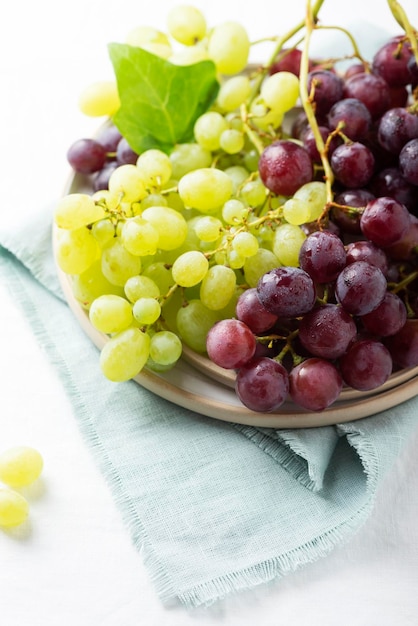 Raisin rouge et jaune sur la nappe en lin blanc