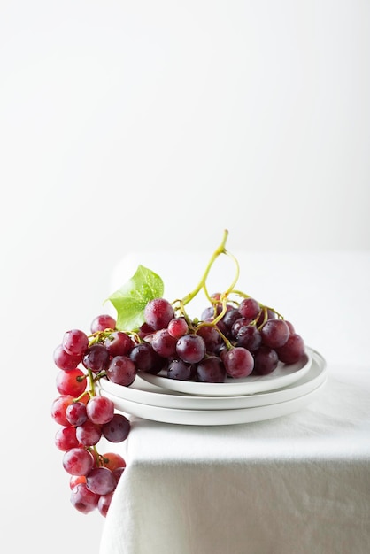 Raisin rouge sur la nappe en lin blanc