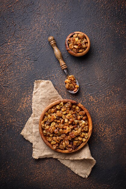 Raisins dans un bol en bois sur fond rouillé