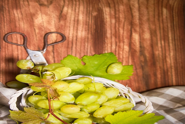 Raisins avec des feuilles sur le fond de bois