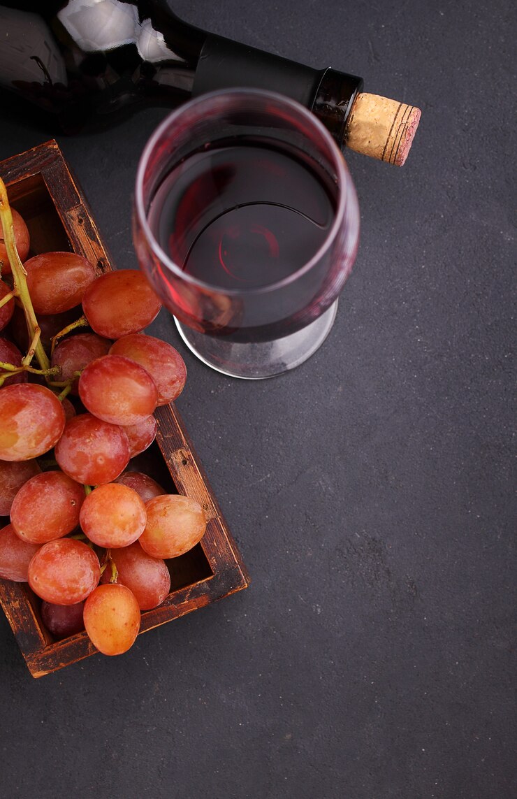 Raisins mûrs, vin rouge et un verre sur un fond noir