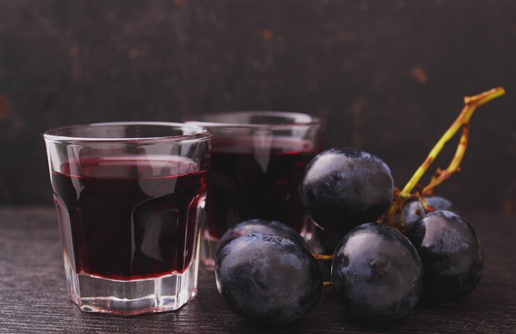 Raisins mûrs, vin rouge et un verre sur un fond noir