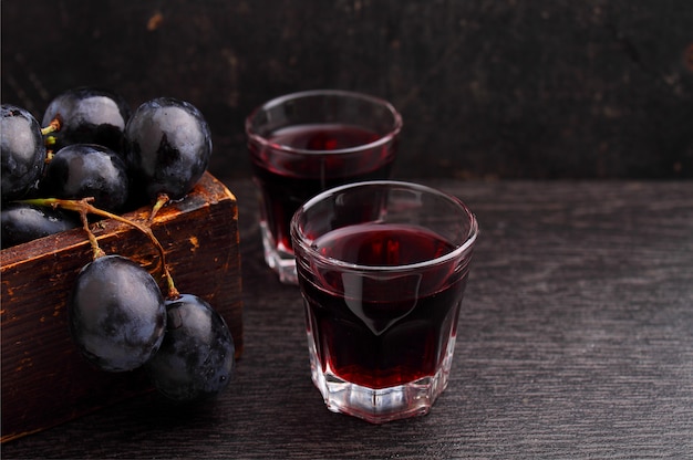 Raisins mûrs, vin rouge et un verre sur un fond noir