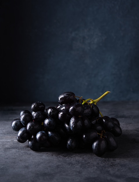 Raisins noirs juteux sur une table sombre