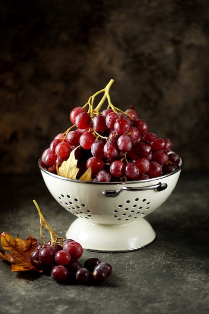 Raisins rouges dans une passoire blanche