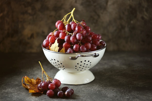 Raisins rouges dans une passoire blanche