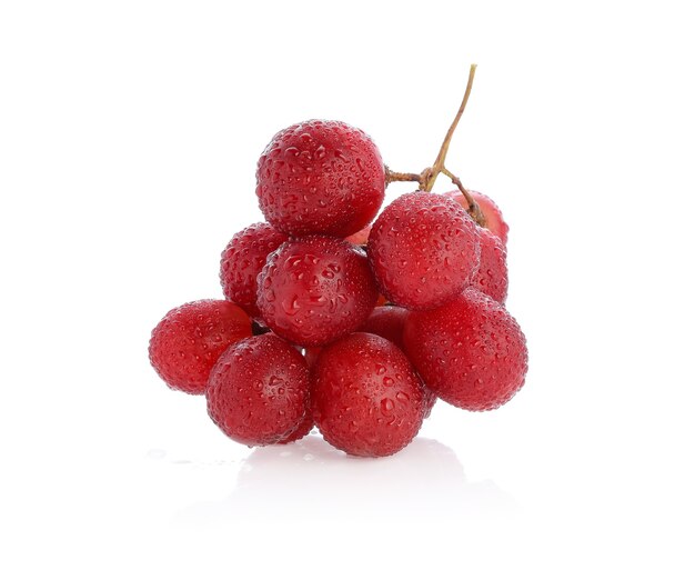 Raisins rouges avec goutte d'eau isolé sur blanc.